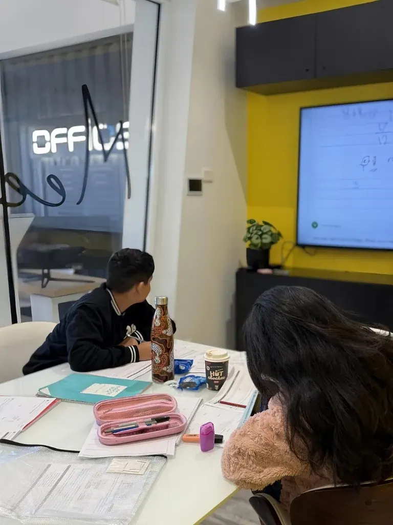 AKademy38 mentor guiding students through learning on an interactive screen